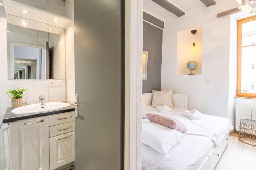 une petite chambre avec un lit et un lavabo dans l'établissement La Tour Médiévale au centre ville, à Annecy