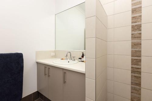 W łazience znajduje się umywalka i lustro. w obiekcie Pelcan Gardens Retreat w mieście Broome