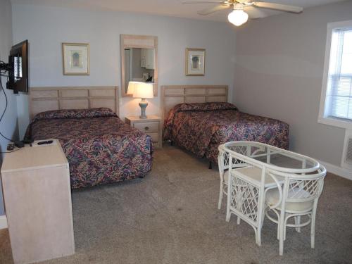a hotel room with two beds and a table at Brunswick Plantation Villa 1005 in Calabash