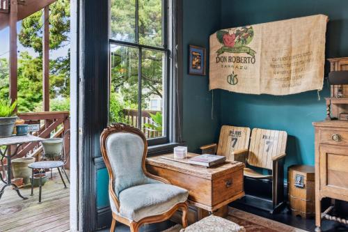 Historic & Charming Victorian Home Sleeps 11 في سان فرانسيسكو: غرفة بها مكتب وكراسي ونافذة