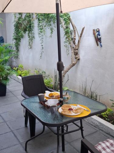 einen Tisch mit Essen drauf mit einem Regenschirm in der Unterkunft Casa Santiago Son in Antigua Guatemala