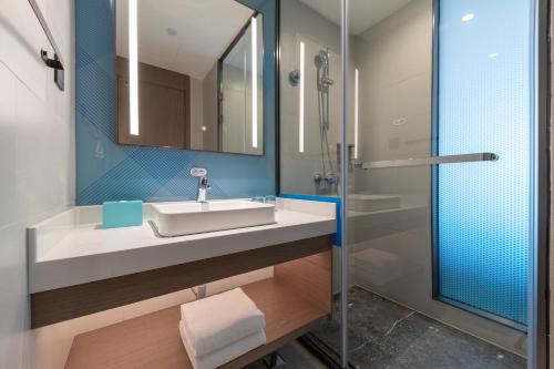 a bathroom with a sink and a shower at Holiday Inn Express Changfeng Park in Shanghai