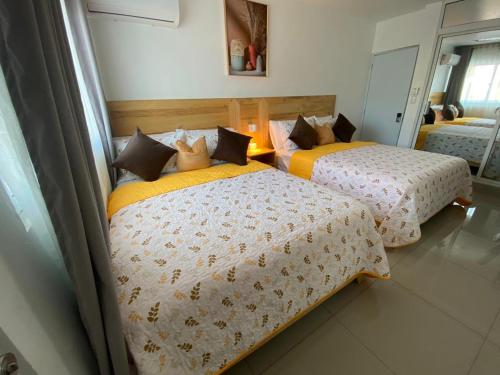 a bedroom with two beds with yellow and white sheets at Room in Samana in Santa Bárbara de Samaná
