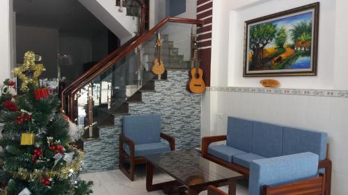 a room with a christmas tree and two chairs and a table at Sunny Homestay Quy Nhơn in Quy Nhon