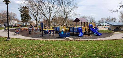 a playground in a park with children playing on it at Parkside Flat - Seacliff Beach Suites in Leamington