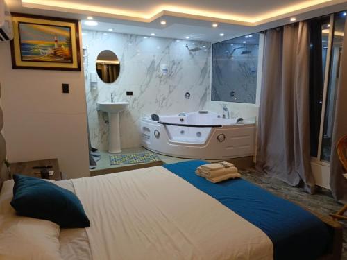 a bedroom with a large bed and a bath tub at Hotel Mar de Plata in Puerto López