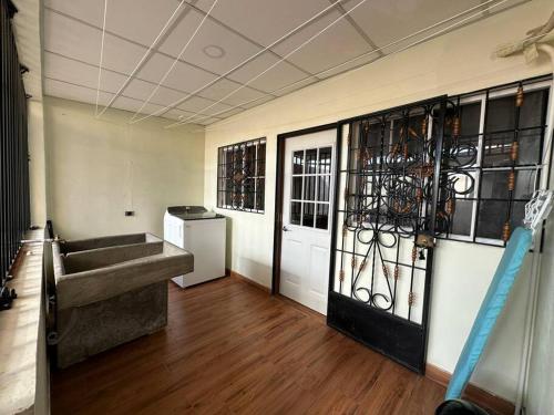 een kamer met een deur met een bank en een raam bij Casa moderna a la vuelta de metrocentro San Miguel in San Miguel