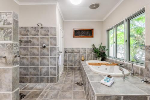uma grande casa de banho com banheira e chuveiro em Seabrook beach house em Port Douglas