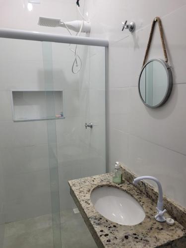 a bathroom with a sink and a shower at Casa nova em Caraguatatuba in Caraguatatuba