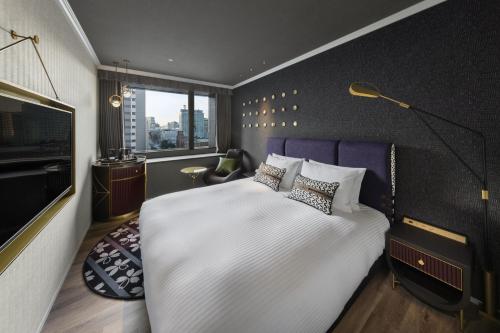 a bedroom with a large bed and a television at Mercure Tokyo Hibiya in Tokyo