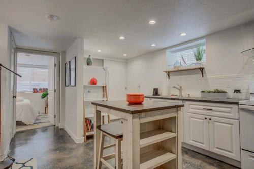 una cucina con armadi bianchi e un'isola con una ciotola d'arancio di 1BD Dog-Friendly Downtown - Urban Neighborhood a Colorado Springs