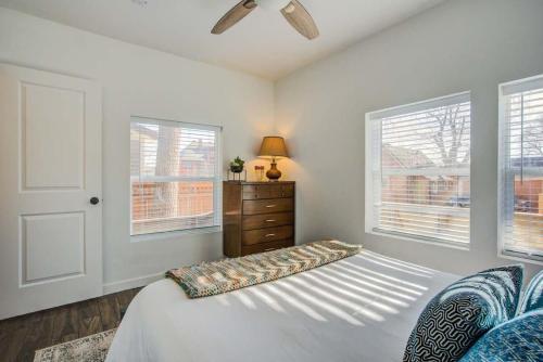 Schlafzimmer mit einem Bett, einer Kommode und Fenstern in der Unterkunft 1BR Lovely Stylish Downtown Close To Everything in Colorado Springs