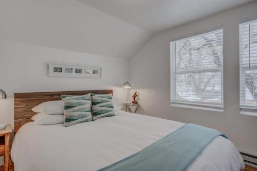 a white bedroom with a bed and a window at Cozy 1BR Dine Play & Sip in Urban Mtn Paradise in Colorado Springs