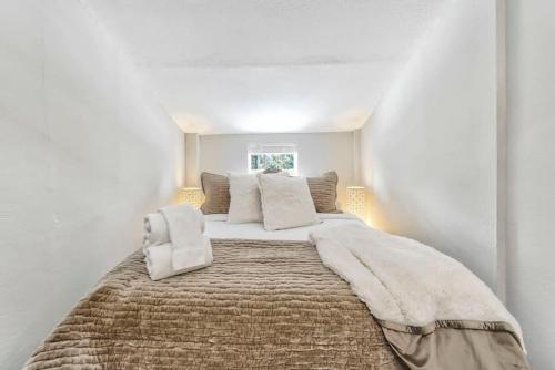a bedroom with a large bed in a white room at 1BR Woodland Hideaway - Downtown and Hiking Nearby in Woodland Park
