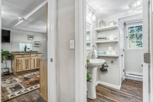 a white bathroom with a sink and a mirror at 1BR Woodland Hideaway - Downtown and Hiking Nearby in Woodland Park
