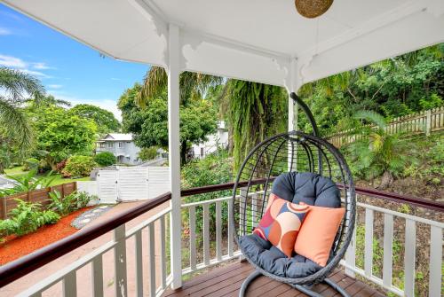 a porch with a swinging chair on a balcony at 'Tropical Refuge' Classic Queenslander Paradise in Stratford