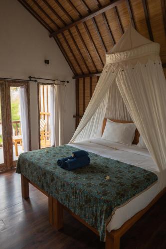 a bed with a bag sitting on top of it at Villa Rika in Gili Trawangan