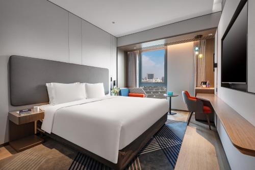 a hotel room with a bed and a television at Holiday Inn Express Changfeng Park in Shanghai