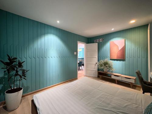 a bedroom with a bed and a green wall at Your Second Home - Garden House in center of Dalat in Da Lat