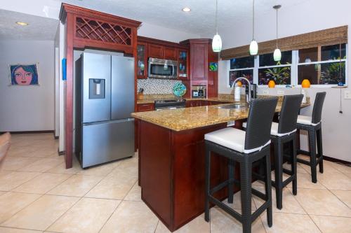 a kitchen with a counter and a refrigerator at Del Playa #1 Condo in West End