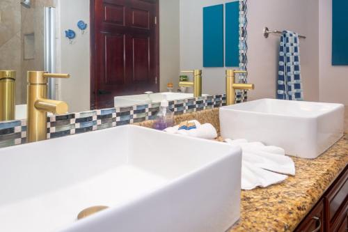 a bathroom with two sinks and a large mirror at Del Playa #1 Condo in West End