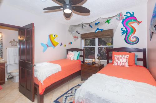 a childs bedroom with two beds and a dragon on the wall at Del Playa #1 Condo in West End