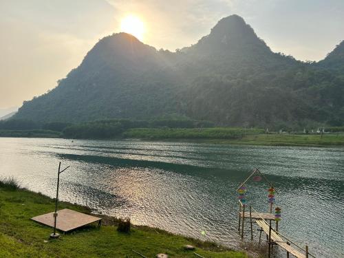 a large body of water with mountains in the background at Son River House in Phong Nha