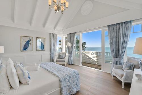 a bedroom with a bed and a view of the ocean at Hampton on View Luxury Clifftop in Campbells Bay in Auckland