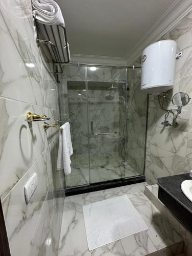 a bathroom with a shower with a glass door at Tuya Queen Pyramids View in Cairo
