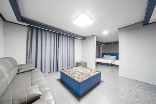 a living room with a couch and a bed at Noblesse Hotel in Jeju
