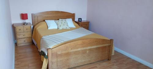 um quarto com uma grande cama de madeira e 2 mesas de cabeceira em Casa das Pedras Altas em Lajes do Pico