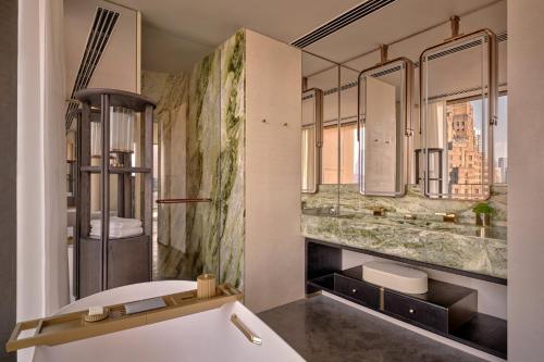 a bathroom with a tub and a sink and mirrors at Regent Shanghai on the Bund in Shanghai