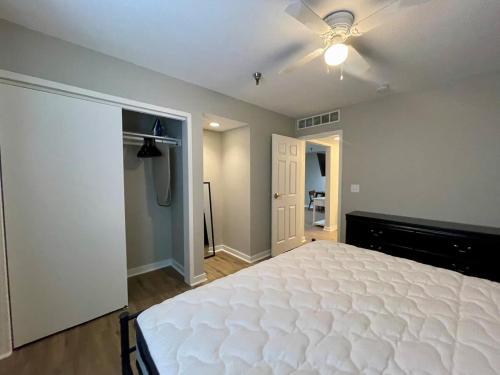 1 dormitorio con cama blanca y ventilador de techo en Cozy Aksarben Living-close to I-80 & WFH desk, en Omaha