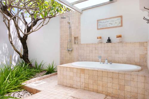y baño con bañera en el jardín. en Villa Puri Pura, en Canggu