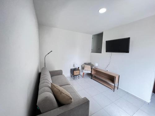 een woonkamer met een bank en een flatscreen-tv bij Casa Madero in Ciudad Madero