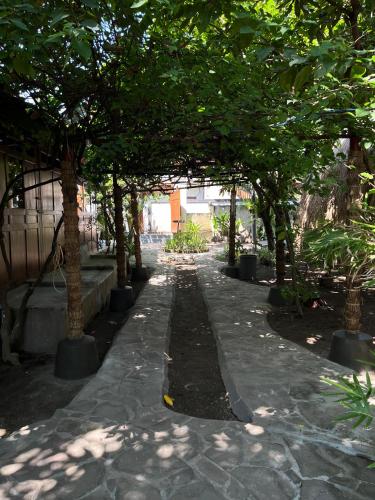 a tree lined walkway with trees in a park at Omah Gili Hotel in Gili Air