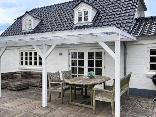 a wooden table and chairs on a patio with a pergola at 5 person holiday home in Øster Assels-By Traum in Øster Assels