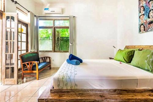 a bedroom with a bed and a chair and a window at Legian Beach 3 Bedroom Villa in Legian