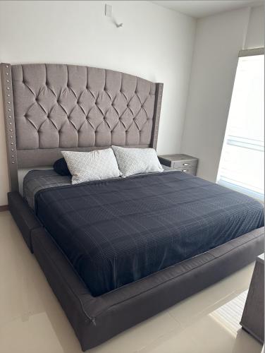 a bedroom with a large bed with a blue comforter at Departamento de Lujo con Alberca Panoramica en Zona Metropolitana de Guadalajara in Guadalajara