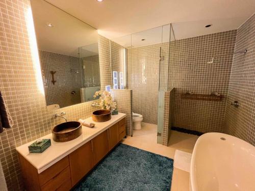 a bathroom with a sink and a toilet and a shower at AP Natai Luxury Beachfront Pool Villas in Phang-nga