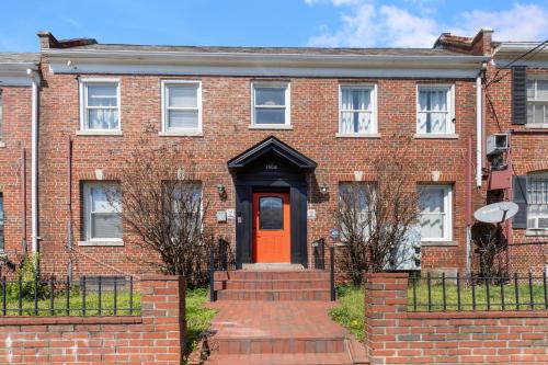 una vieja casa de ladrillo con una puerta roja en Luxury 2bd Haven in DC's Heart!, en Washington