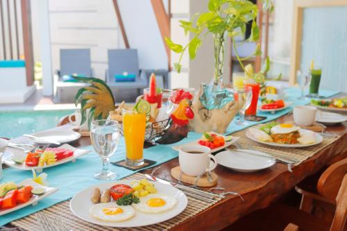 Ein Tisch voller Teller mit Frühstücksspeisen und Getränken in der Unterkunft Sudha Villa Bali A in Seminyak