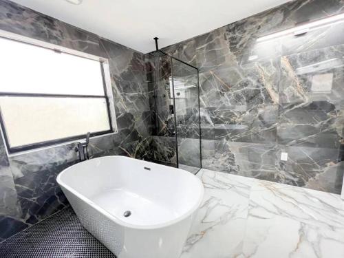 a bathroom with a tub and a sink and a window at Modern Lakefront Home in Wellington