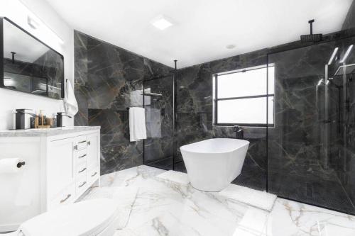 a bathroom with a toilet and a sink and a tub at Modern Lakefront Home in Wellington
