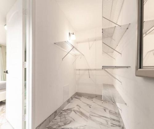 uma casa de banho com uma cabina de duche em vidro e piso em mármore. em Modern Lakefront Home em Wellington