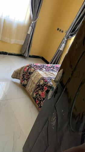 Bett in einem Zimmer mit einem Kissen auf dem Boden in der Unterkunft SHORT Rental in Ilorin