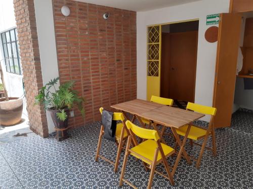 einen Holztisch und gelbe Stühle in einem Zimmer in der Unterkunft Estudio en casa Fatima para 2 personas in Guadalajara