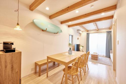 a dining room with a table and a surfboard on the wall at eni.konohana in Osaka
