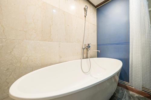 a white bath tub in a bathroom with a shower at Noblesse Hotel in Jeju