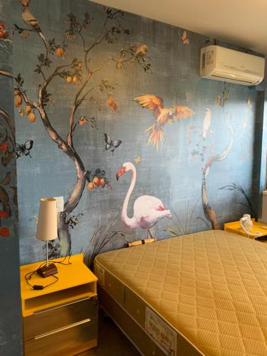 a bedroom with a mural of birds on the wall at Flat Espaço Itaim BIBI I in Sao Paulo
